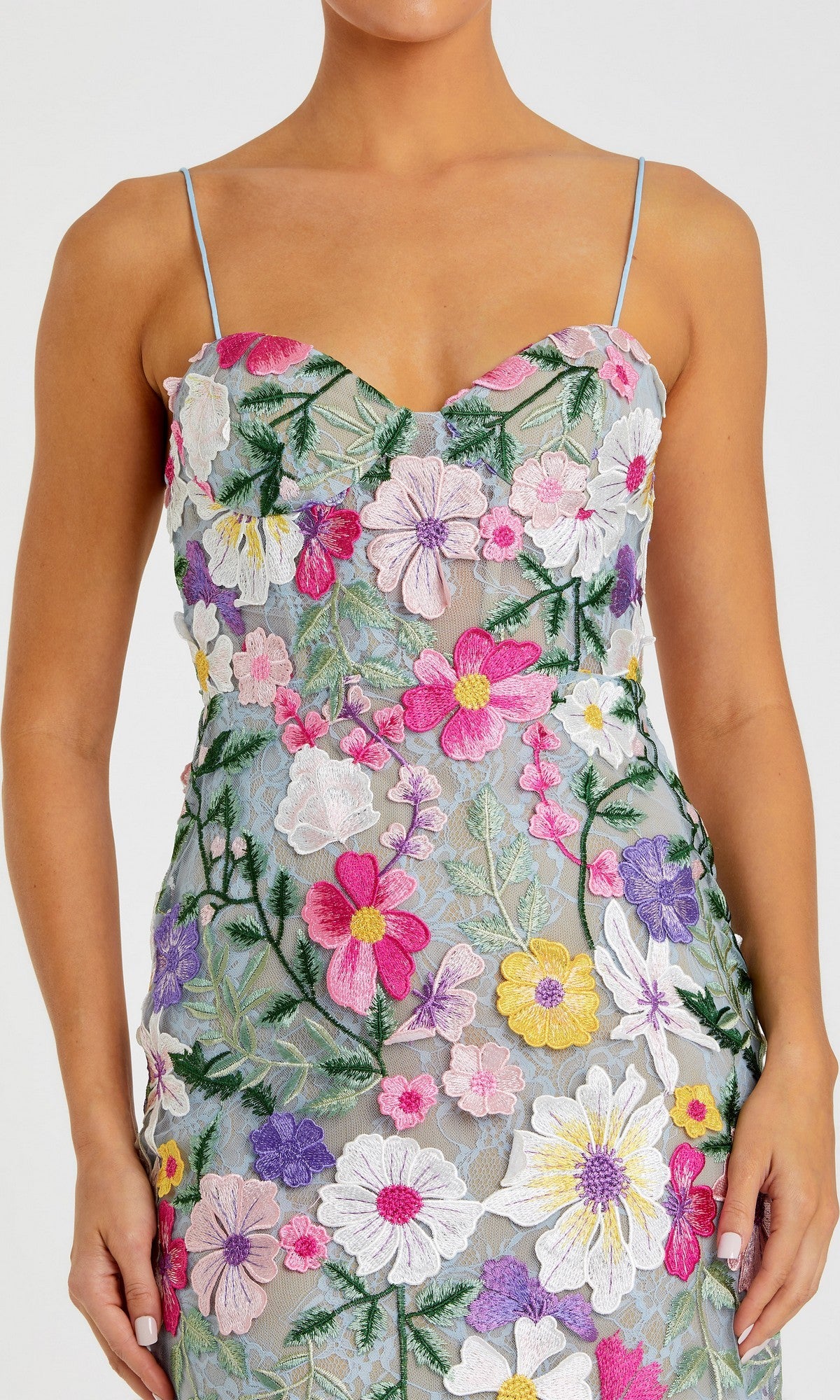 A woman wears the Mac Duggal 68897 long formal dress, a sleeveless evening gown with thin straps and colorful floral embroidery on sheer fabric.